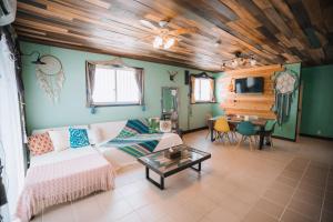 a living room with a couch and a table at Cottage ke'oke'o in Yomitan