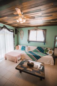 a living room with two beds and a table at Cottage ke'oke'o in Yomitan +140 photos
