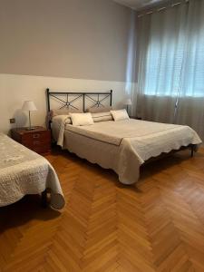 a bedroom with two beds and a wooden floor at Big Brother Bed & Rooms in Treviso