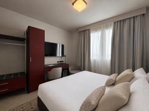 a hotel room with a bed and a television at Hotel Fiera Rimini in Rimini
