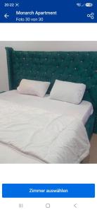 a picture of a bed with white sheets and pillows at Monarch Apartment in Oshogbo