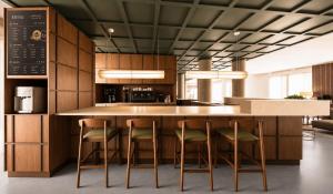 a kitchen with a large island with four bar stools at Hotel Fiera Rimini in Rimini
