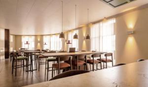 a large room with tables and chairs and windows at Hotel Fiera Rimini in Rimini +5 photos
