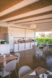 a dining room with tables and chairs and a kitchen at Bed & Breakfast Villa Michela Alezio in Alezio