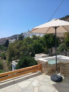 eine Terrasse mit Bank und Sonnenschirm in der Unterkunft Alchemis in Kardhianí + 5 Fotos