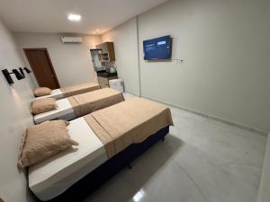 a hospital room with two beds and a tv at Loft Hage in Belém
