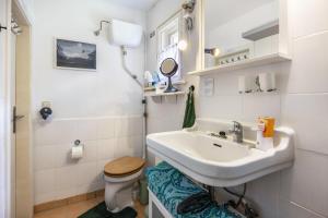 a bathroom with a sink and a toilet at Fuchsrevier Fox District Apartment in Erkerode +15 photos