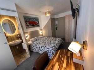 a hotel room with a bed and a sink at Mauguio Center Hôtel in Mauguio
