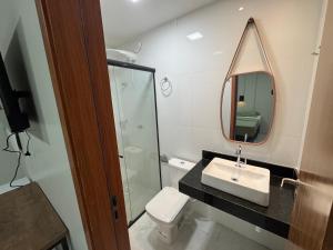 a bathroom with a sink and a mirror and a toilet at Loft Hage in Belém