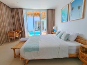 a bedroom with a large bed with a view of the ocean at Villa Chioni Uluwatu by LODGELINK BALI in Uluwatu