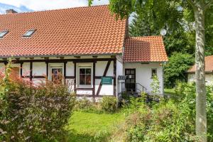 a small white house with an orange roof at Fuchsrevier Fox District Apartment in Erkerode