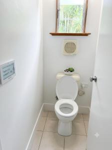 a bathroom with a white toilet with a window at ALRA2 Accommodations in Brisbane