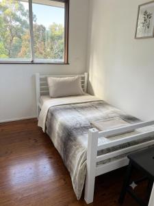 a white bed in a room with a window at ALRA2 Accommodations in Brisbane