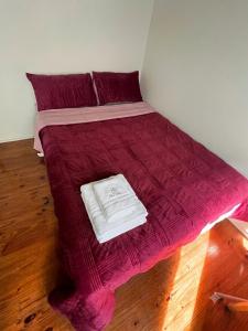 a bed with a red comforter in a room at ALRA2 Accommodations in Brisbane