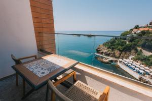 a balcony with a table and chairs and the ocean at Hotel Mediterraneo Liman in Ulcinj