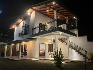 a large white house with a balcony and stairs at The villa Evans in Pitiduwa