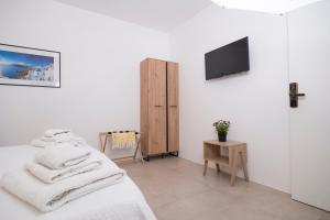 a white room with a bed and a tv at Tenuta Rapillo in Castellammare del Golfo