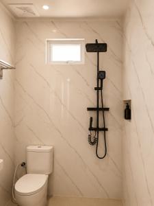 a bathroom with a toilet and a shower at Bali Queen Cottage in Pabean Buleleng