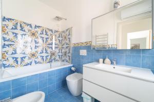 a blue tiled bathroom with a toilet and a sink at Tia Maria - Tradizione e Autenticità in Ploaghe +33 photos