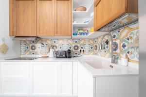 a kitchen with white cabinets and a sink at Tia Maria - Tradizione e Autenticità in Ploaghe