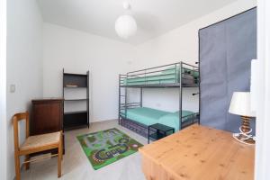 a room with bunk beds and a table and a chair at Tia Maria - Tradizione e Autenticità in Ploaghe