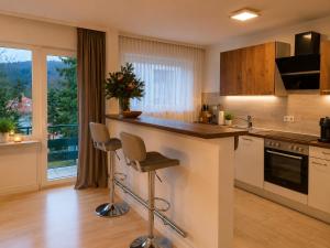 a kitchen with a counter with two stools in it at Moscow Areal Suite in Baden-Baden