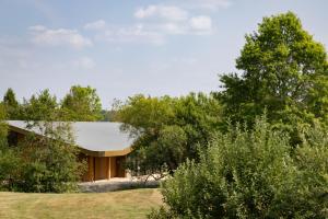 a house in a field with trees at Bernwood Park Hotel in Boarstall
