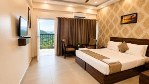 a bedroom with a bed and a desk and a window at Pleasant Hill Resort - Munnar in Munnar