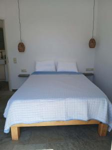 ein Schlafzimmer mit einem Bett mit einer blau-weißen Bettdecke in der Unterkunft Alchemis in Kardhianí