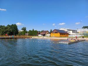 a group of people on a dock in the water at Apartament Centrum in Giby