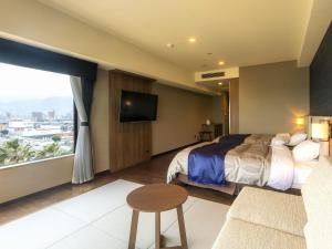 a hotel room with a bed and a large window at REX HOTEL Beppu in Beppu