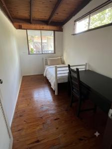 a bedroom with a bed and a desk and two windows at ALRA2 Accommodations in Brisbane +1 photo