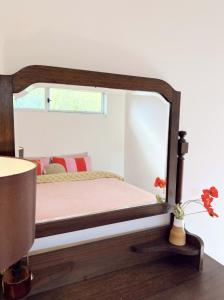 a bedroom with a wooden bed with a mirror at Studio Jean - Dog-Friendly in Bremer Bay