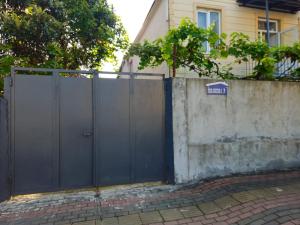 a fence with a gate in front of a house at George House in Batumi