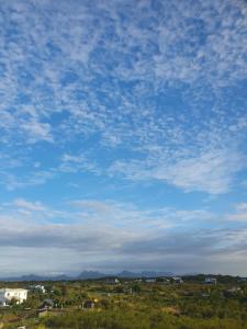a blue sky with clouds above a field with houses at Hyacinth Golf& Sea in Grand-Baie