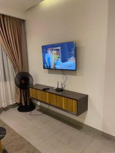 ein Wohnzimmer mit einem Fernseher an der Wand in der Unterkunft Solaris in Lagos