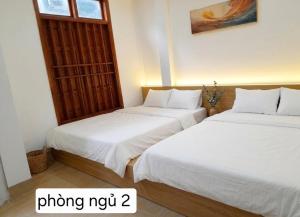 two beds sitting next to each other in a room at Mùi Oanh Homestay sát biển in Sầm Sơn
