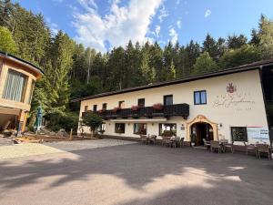 a building with chairs and tables in front of it at Waldhotel Bad Jungbrunn in Tristach