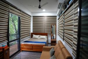 a small bedroom with a bed and a couch at Kaivalyam Homestay in Wayanad