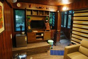 a living room with a tv and a couch at Kaivalyam Homestay in Wayanad