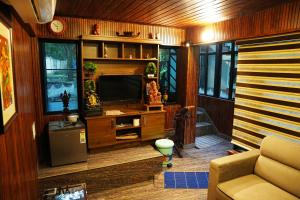 a living room with a television and a couch at Kaivalyam Homestay in Wayanad