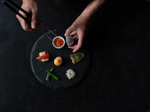 a person holding a glass of wine next to a plate of food at YOKI Matsushima in Matsushima