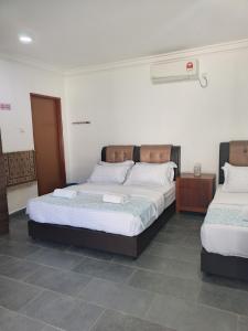 a bedroom with two beds in a room at Aimers Lodge in Dungun
