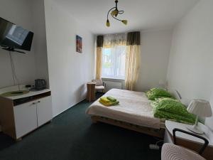 a small room with a bed and a television at Bursztynek in Gdynia +2 photos