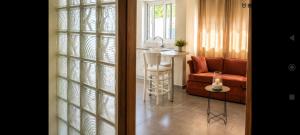 a living room with a couch and a sink and a table at Vasiliki apartment in Kalamata