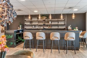 eine Bar in einem Restaurant mit Hockern in der Unterkunft Hotel Kongens Ege in Randers