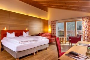 a hotel room with a bed and a table at Hotel Walserberg in Warth am Arlberg