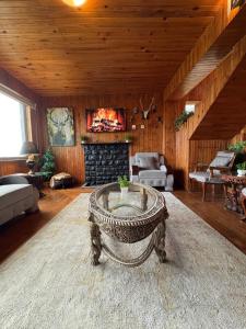 a living room with a table and a fireplace at Haven Hilltop Cottage, Dunga Gali in Dunga Gali