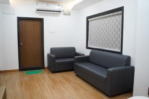a waiting room with two chairs and a door at Hindustan Hotels in Warangal