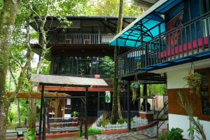 a building with trees in front of it at Kaivalyam Homestay in Wayanad